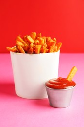 Photo of Tasty ketchup and fried carrots on color background