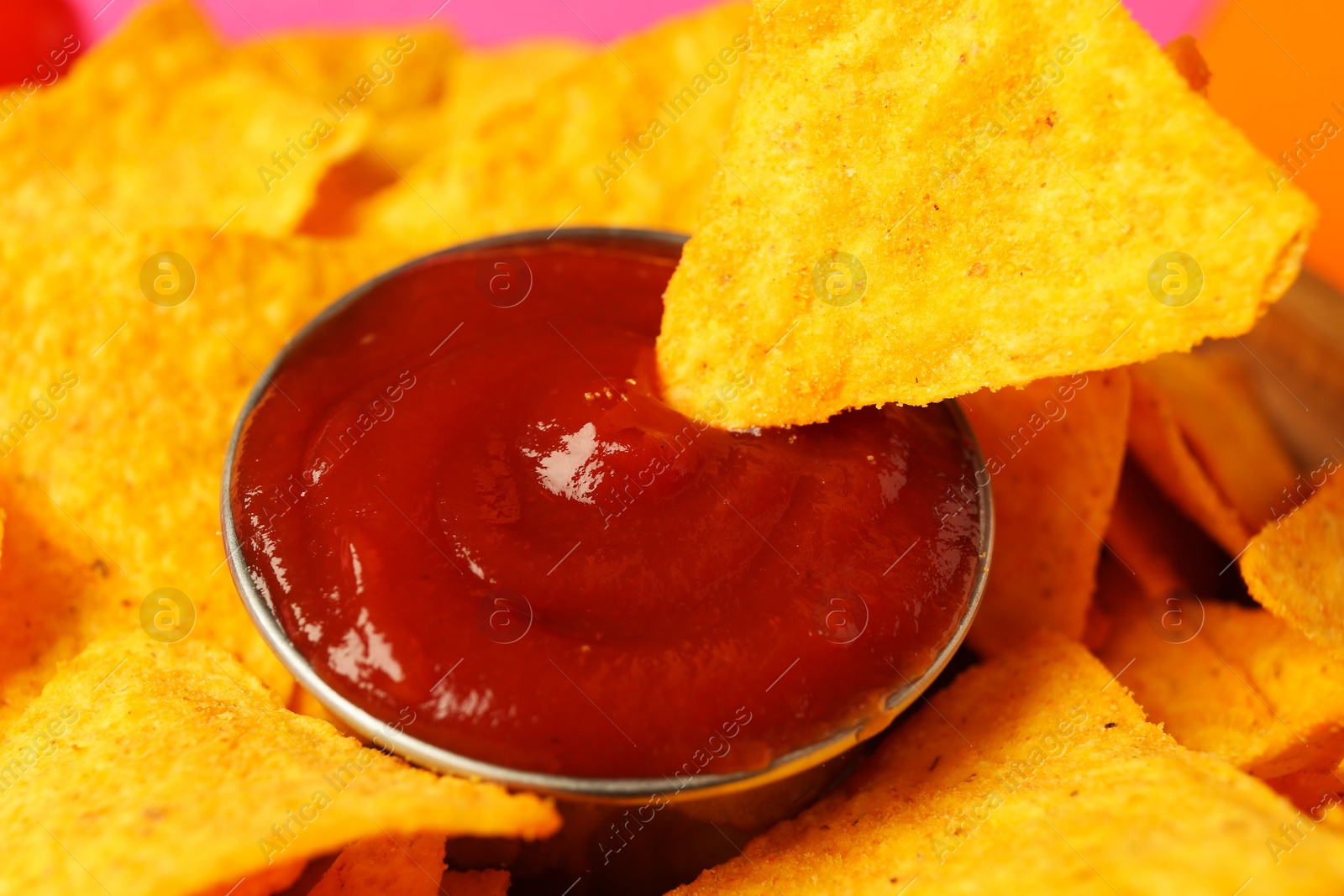 Photo of Tasty ketchup and nachos on plate, closeup