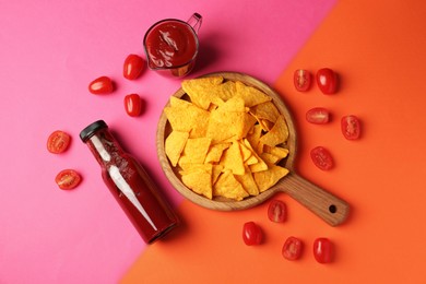 Photo of Tasty ketchup, tomatoes and nachos on color background, flat lay