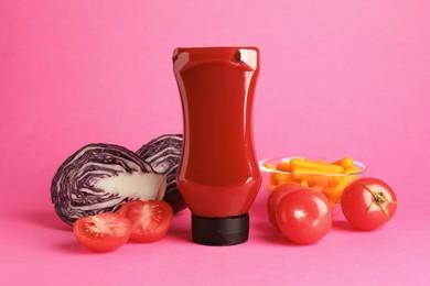 Photo of Tasty ketchup and vegetables on pink background