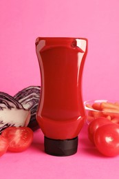 Photo of Tasty ketchup and vegetables on pink background