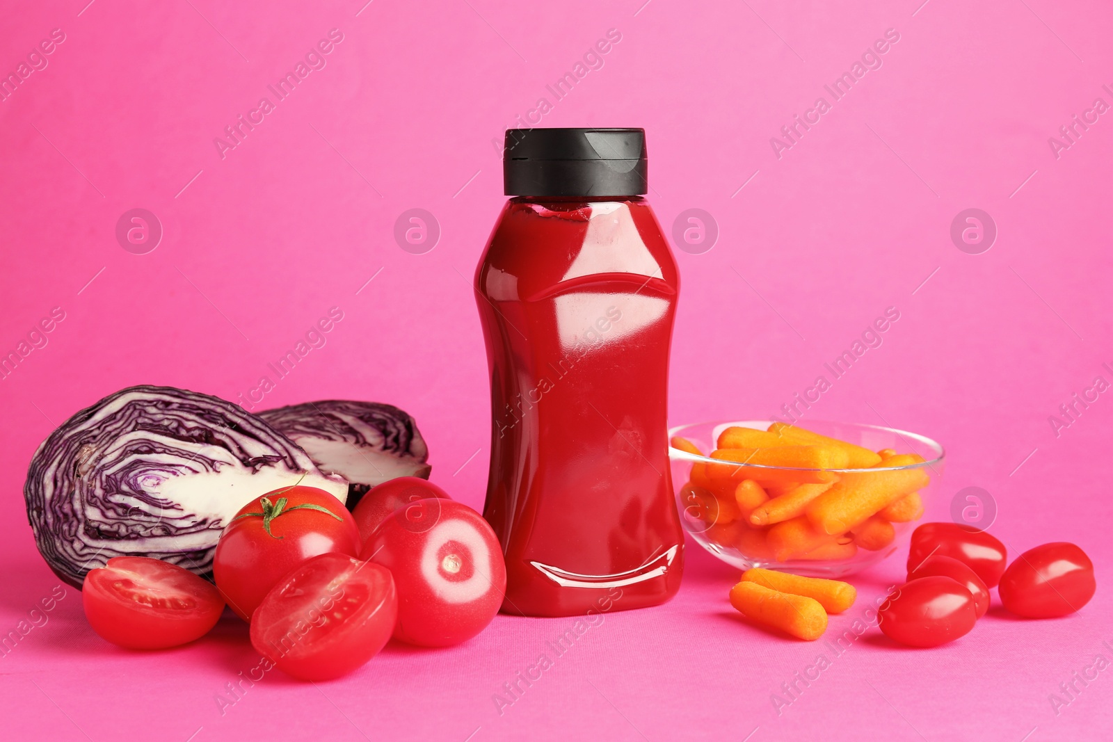 Photo of Tasty ketchup and vegetables on pink background