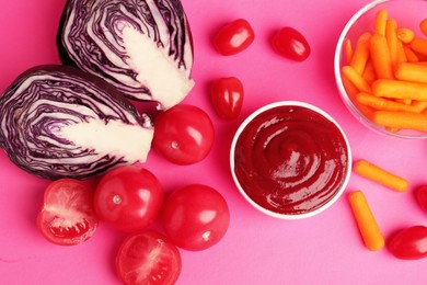 Photo of Tasty ketchup and vegetables on pink background, flat lay