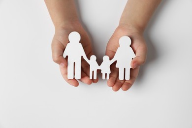 Photo of Child holding figure of family on white background, top view