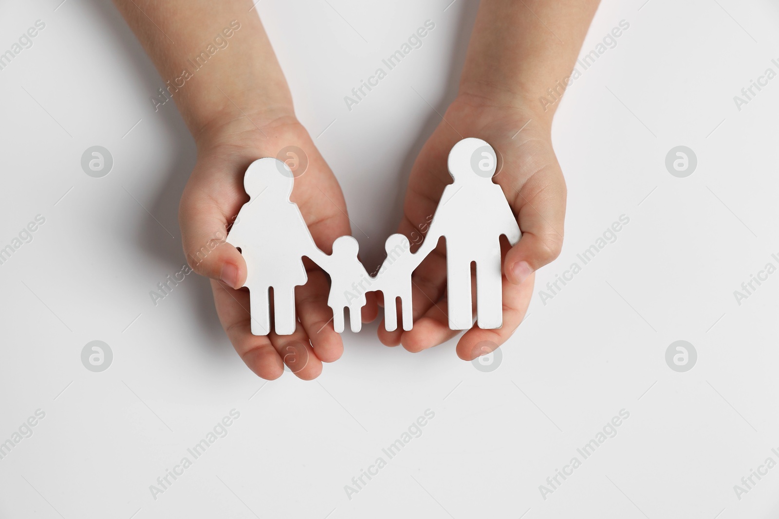 Photo of Child holding figure of family on white background, top view