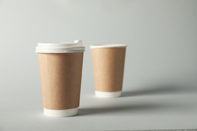 Photo of Paper cups on grey background, selective focus. Mockup for design