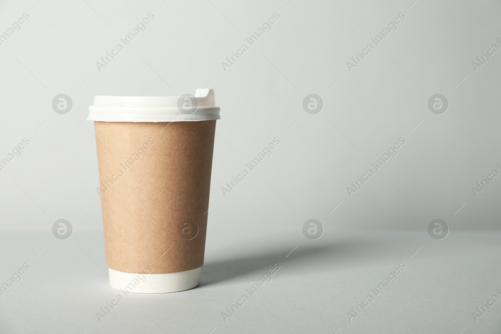 Paper cup with lid on grey background. Mockup for design Photo of Paper cup with lid on grey background. Mockup for design