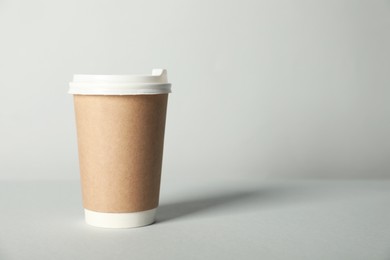 Photo of Paper cup with lid on grey background. Mockup for design