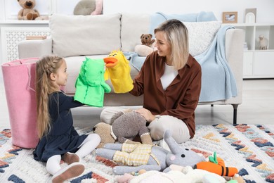 Photo of Little helper. Daughter and mother putting away toys together at home