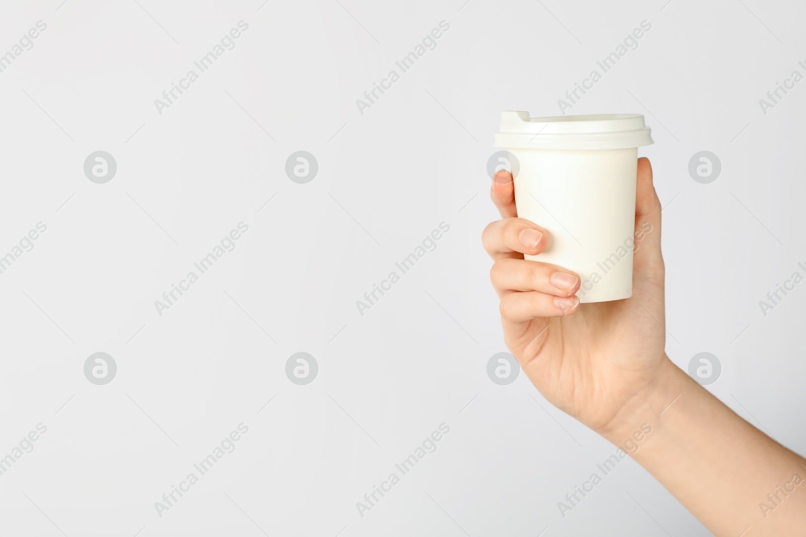 Woman holding paper cup on white background, closeup. Mockup for design Photo of Woman holding paper cup on white background, closeup. Mockup for design