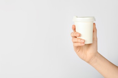 Photo of Woman holding paper cup on white background, closeup. Mockup for design