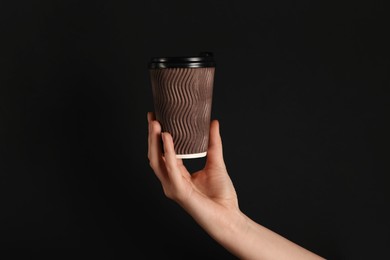 Photo of Woman holding paper cup on black background, closeup. Mockup for design