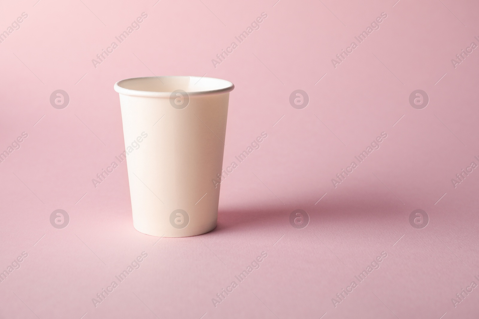 One paper cup on pink background. Mockup for design Photo of One paper cup on pink background. Mockup for design