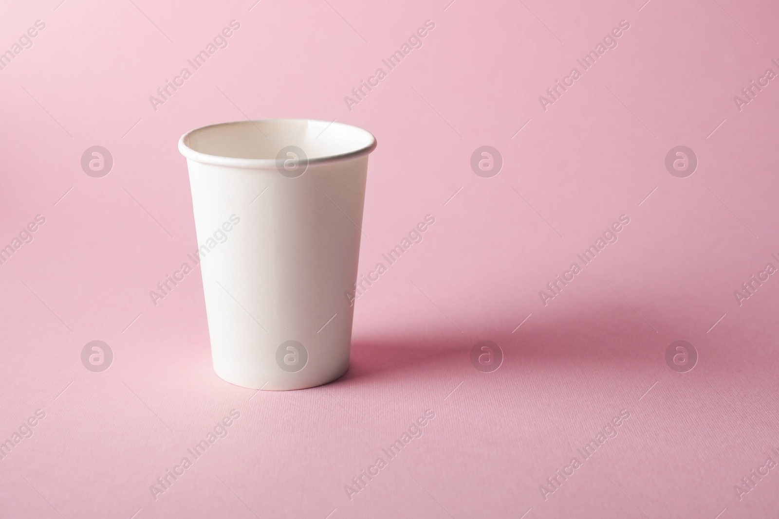 One paper cup on pink background. Mockup for design Photo of One paper cup on pink background. Mockup for design