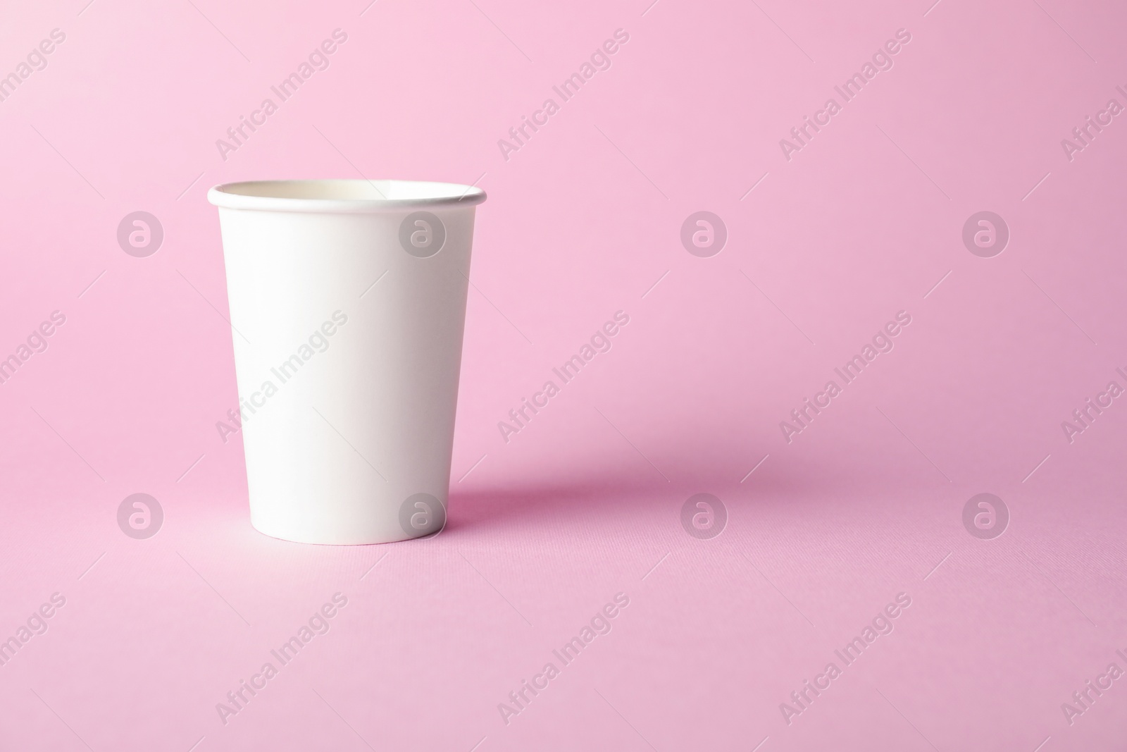 One paper cup on pink background. Mockup for design Photo of One paper cup on pink background. Mockup for design