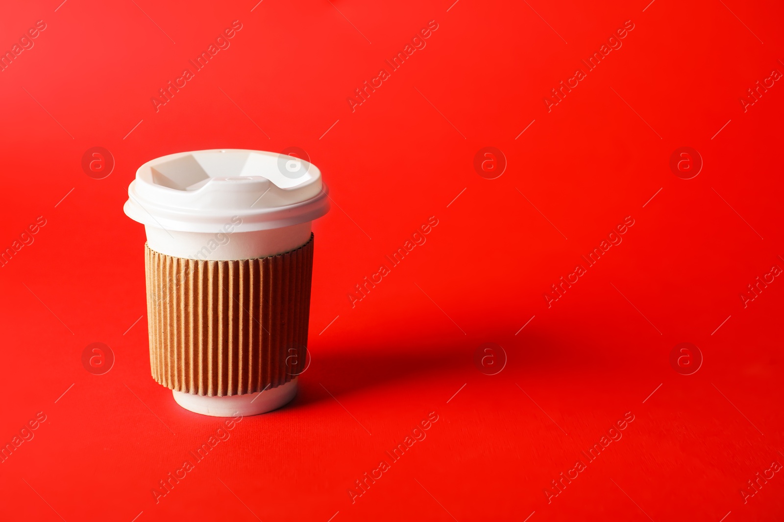 One paper cup on red background. Mockup for design Photo of One paper cup on red background. Mockup for design