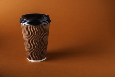 Photo of One paper cup on brown background. Mockup for design