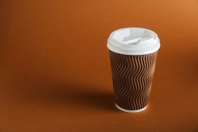 Photo of One paper cup on brown background. Mockup for design