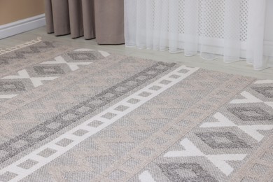 Photo of Stylish soft rug with pattern on floor indoors