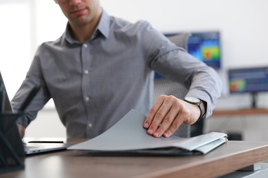 Photo of Financial trading specialist with folder at table in office, closeup