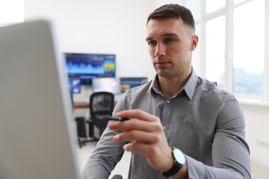 Photo of Financial trading specialist working on computer in office