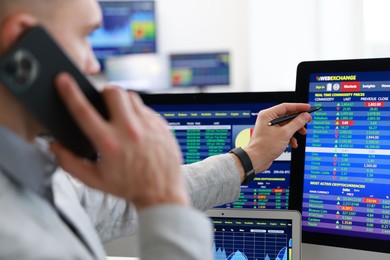 Photo of Financial trading specialist talking on phone in office, selective focus