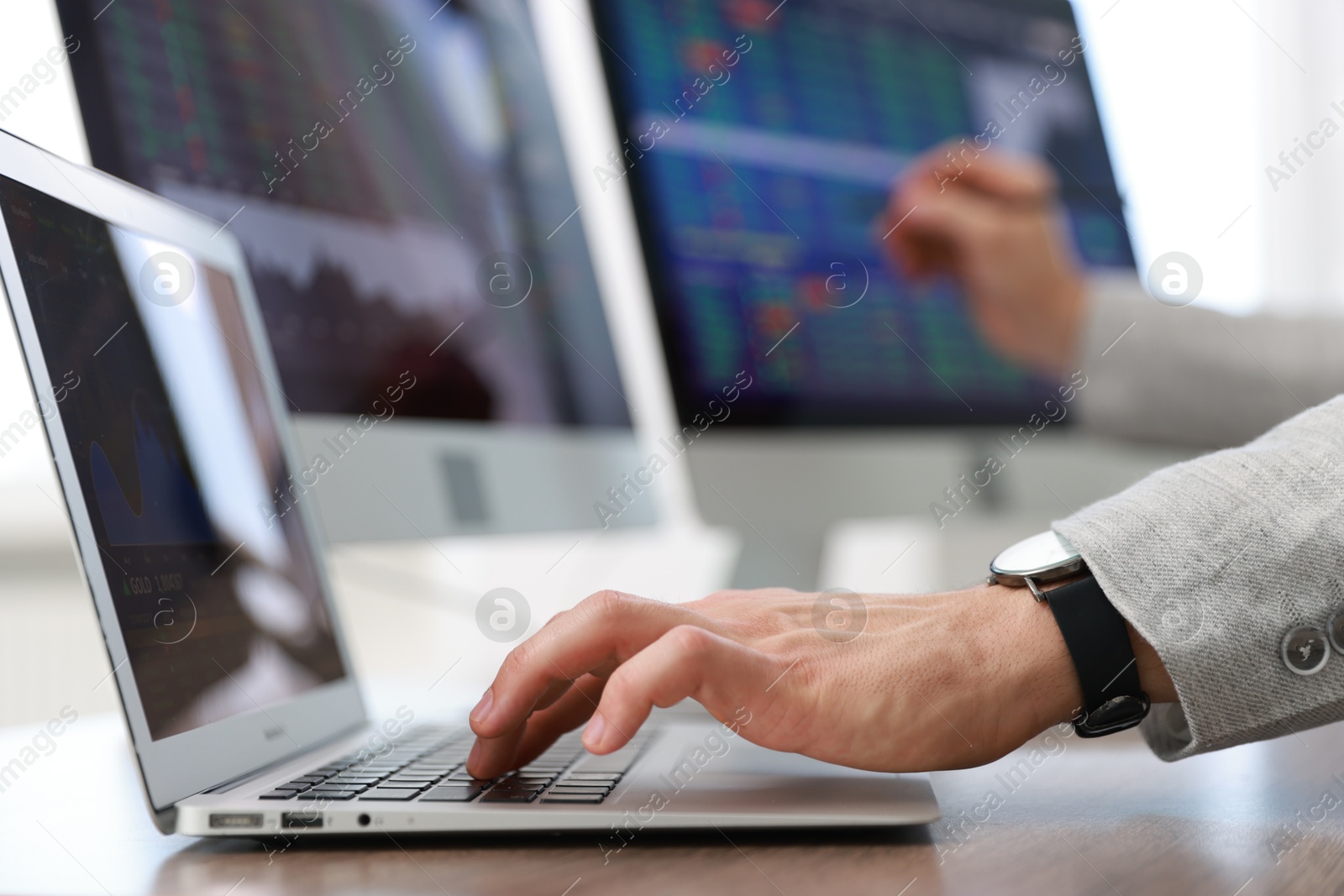 Photo of Financial trading specialist working on laptop in office, closeup