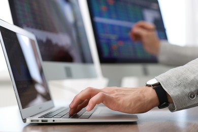 Photo of Financial trading specialist working on laptop in office, closeup