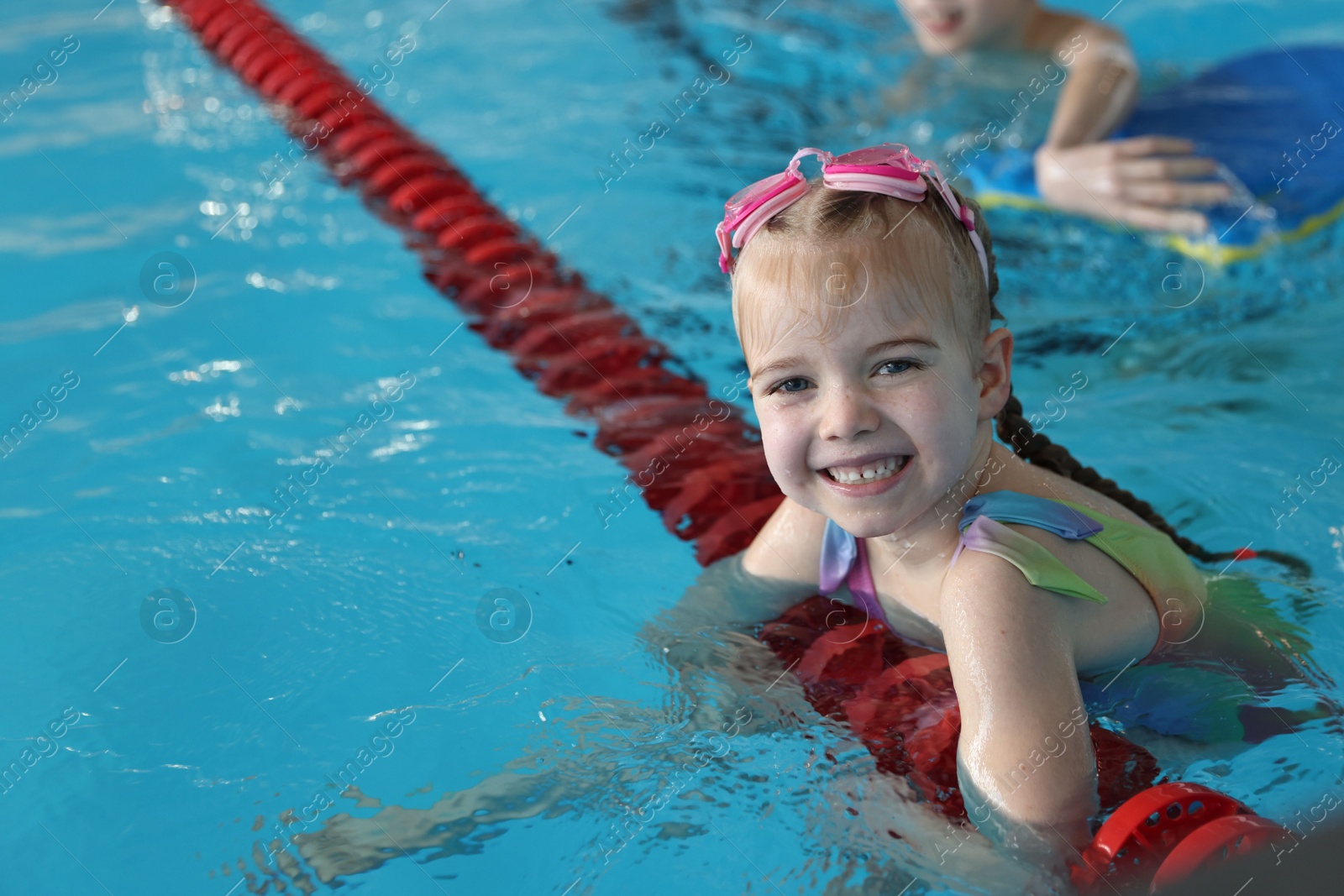 Photo of Children with goggles swimming in pool indoors, selective focus. Space for text