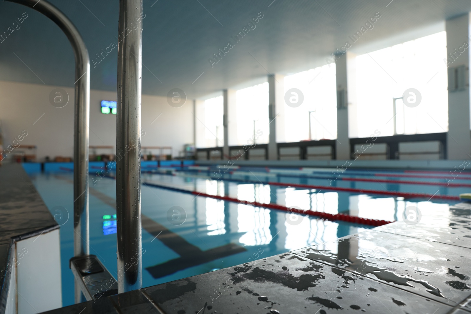 Photo of Swimming pool with clean water and ladder indoors, closeup