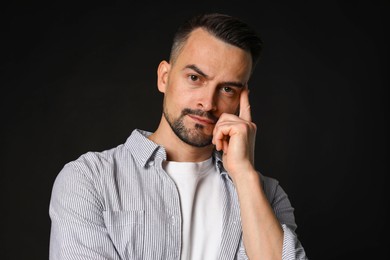 Photo of Portrait of handsome middle aged man on black background