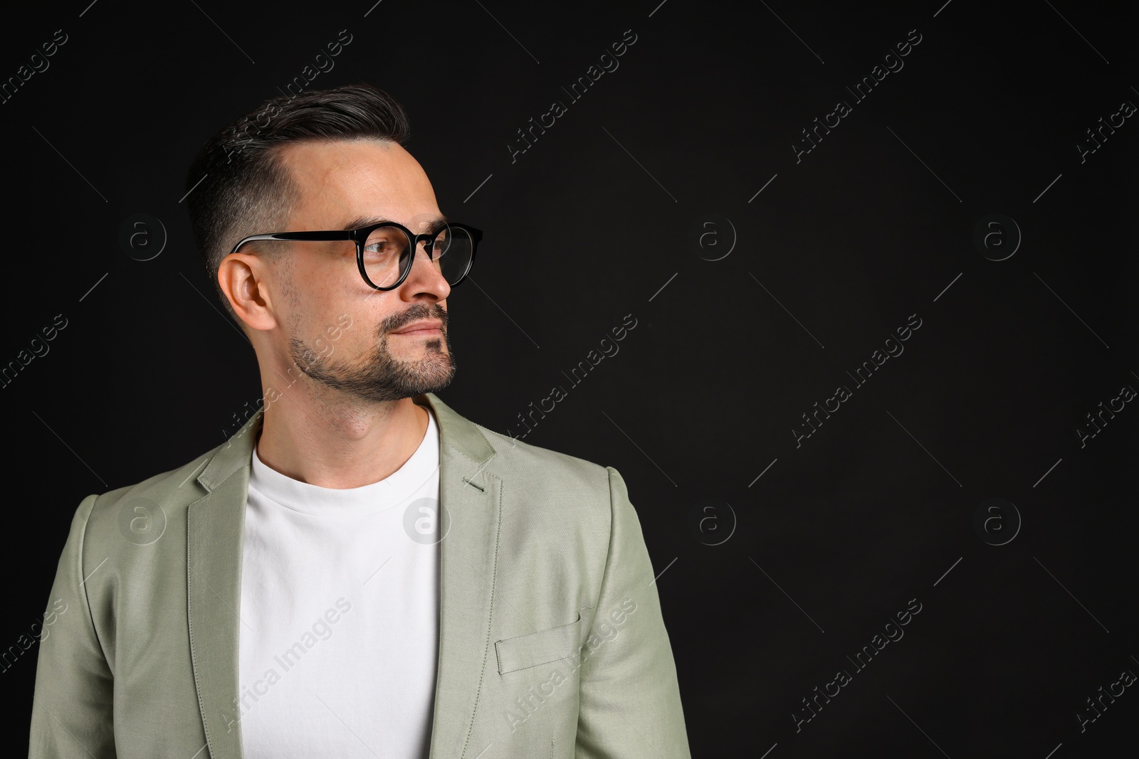 Photo of Portrait of handsome middle aged man on black background, space for text