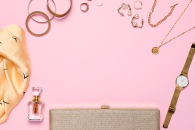 Photo of Frame made of many stylish jewelry, perfume and accessories on pink background, flat lay. Space for text