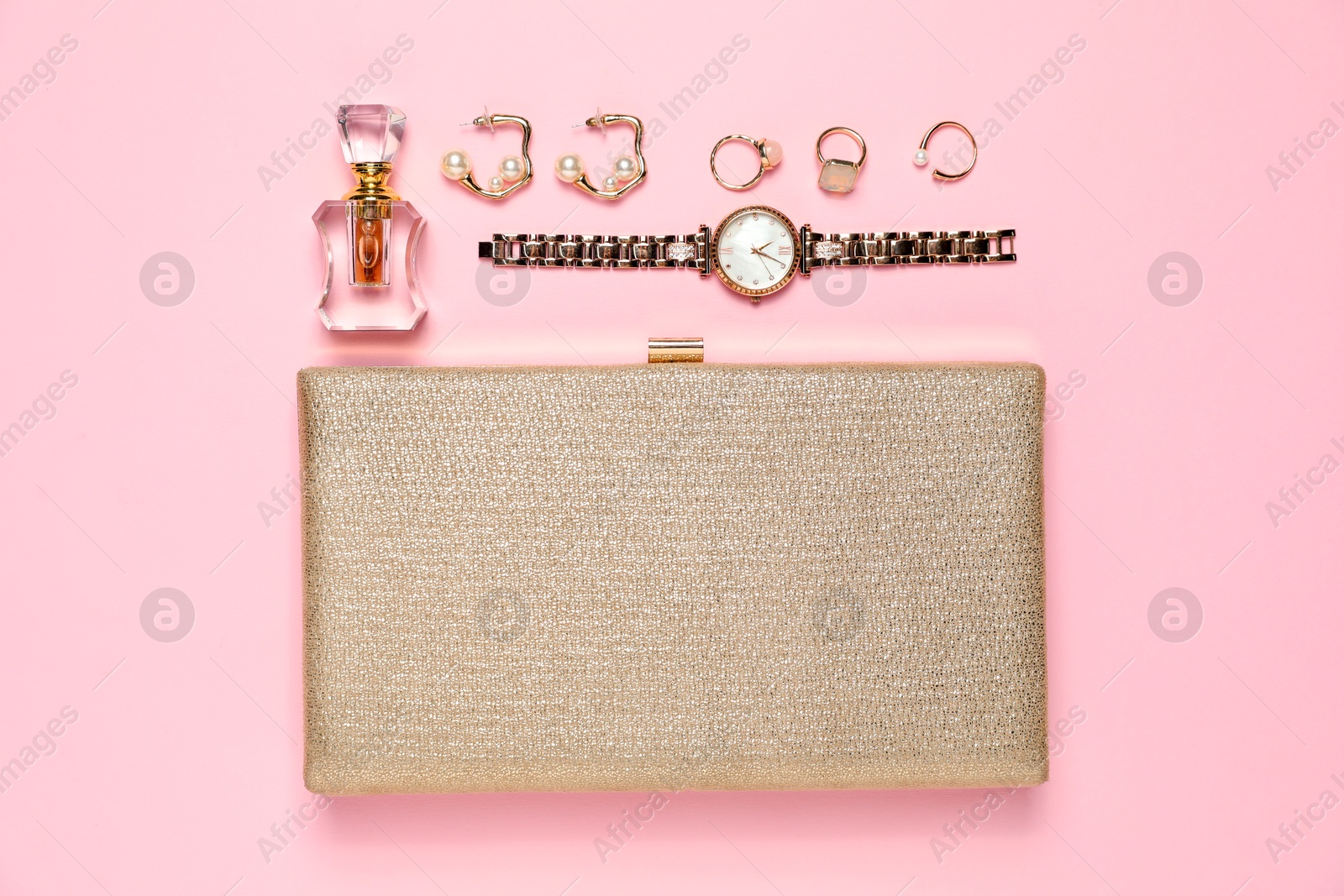 Photo of Many stylish jewelry, perfume and accessories on pink background, flat lay