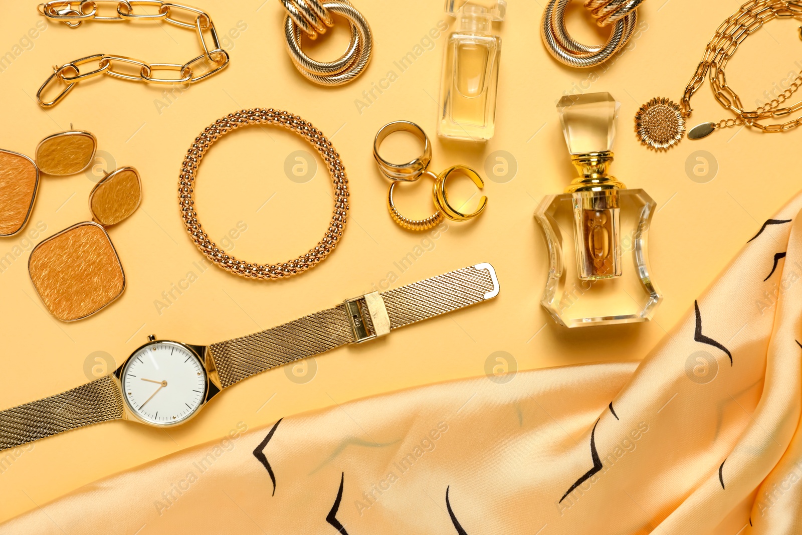 Photo of Many stylish jewelry, perfume and accessories on pale yellow background, flat lay