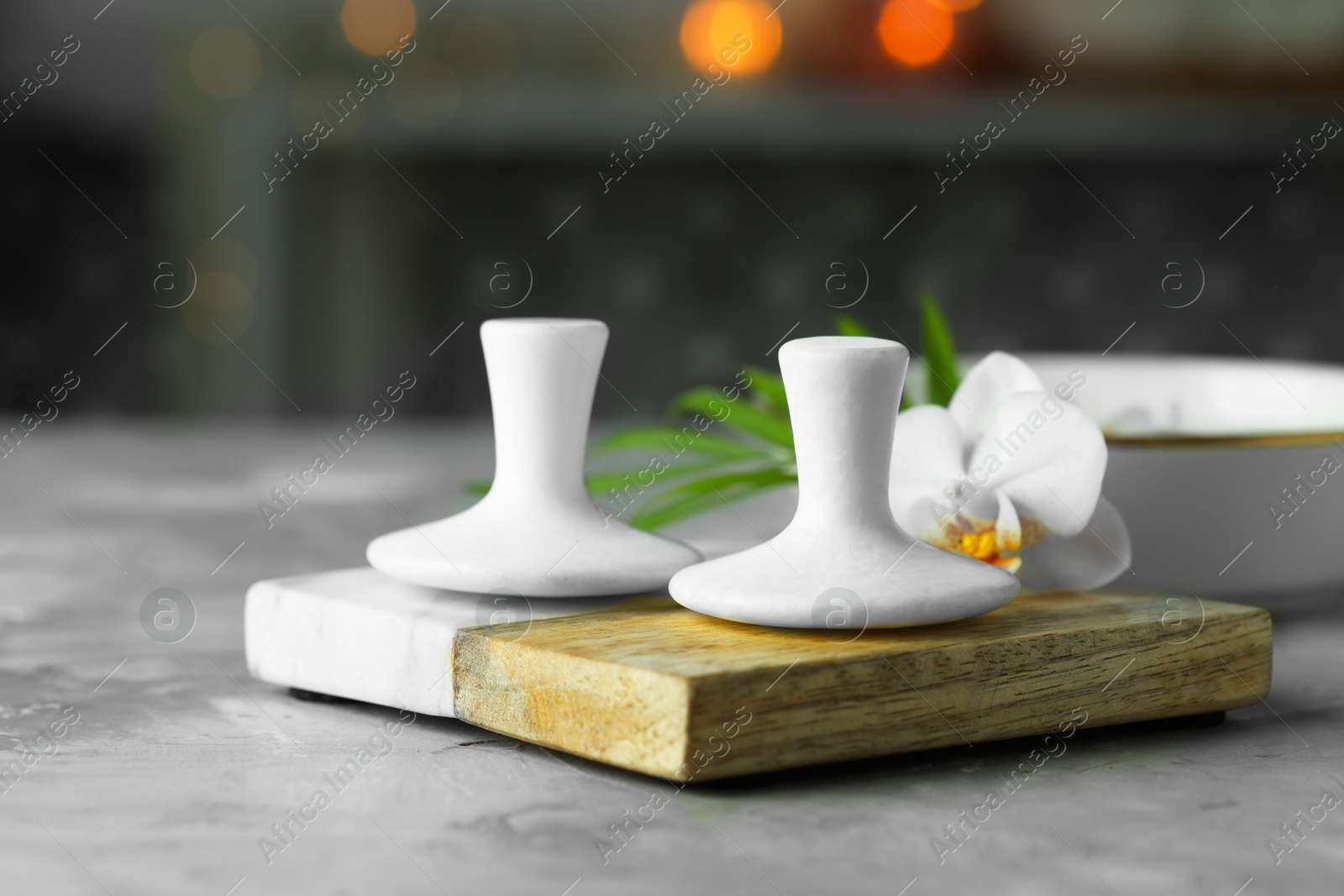 Photo of Spa stones and orchid flower on grey table, closeup