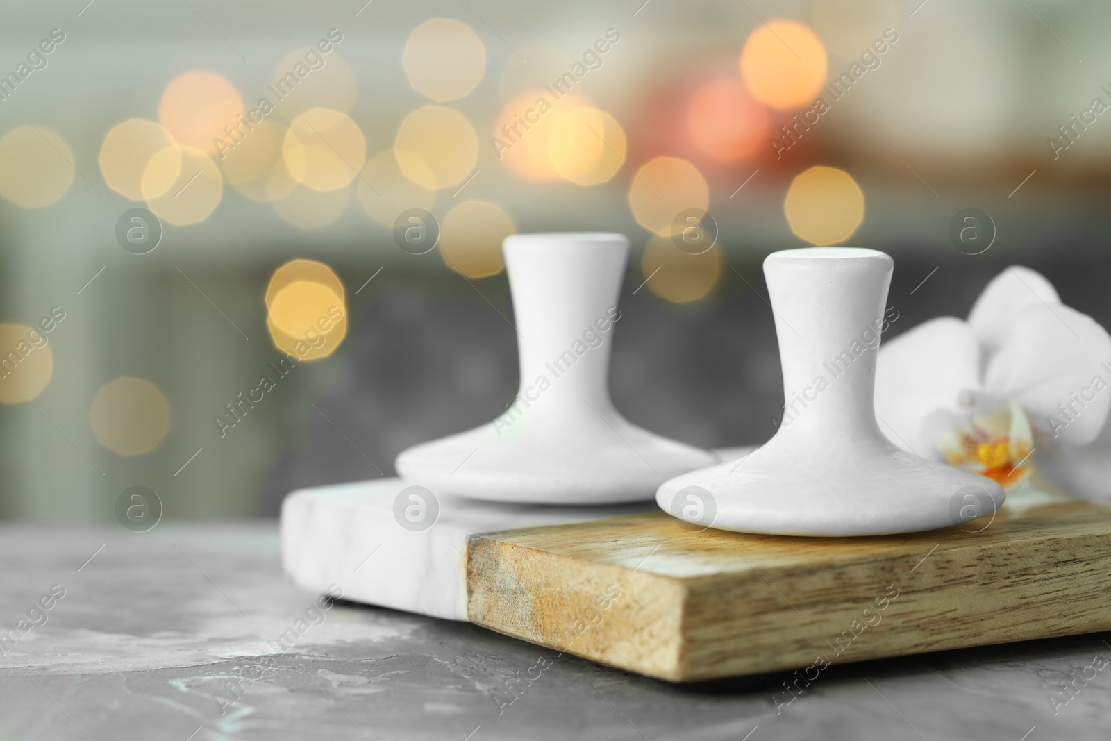 Photo of Spa stones and orchid flower on grey table, closeup. Space for text