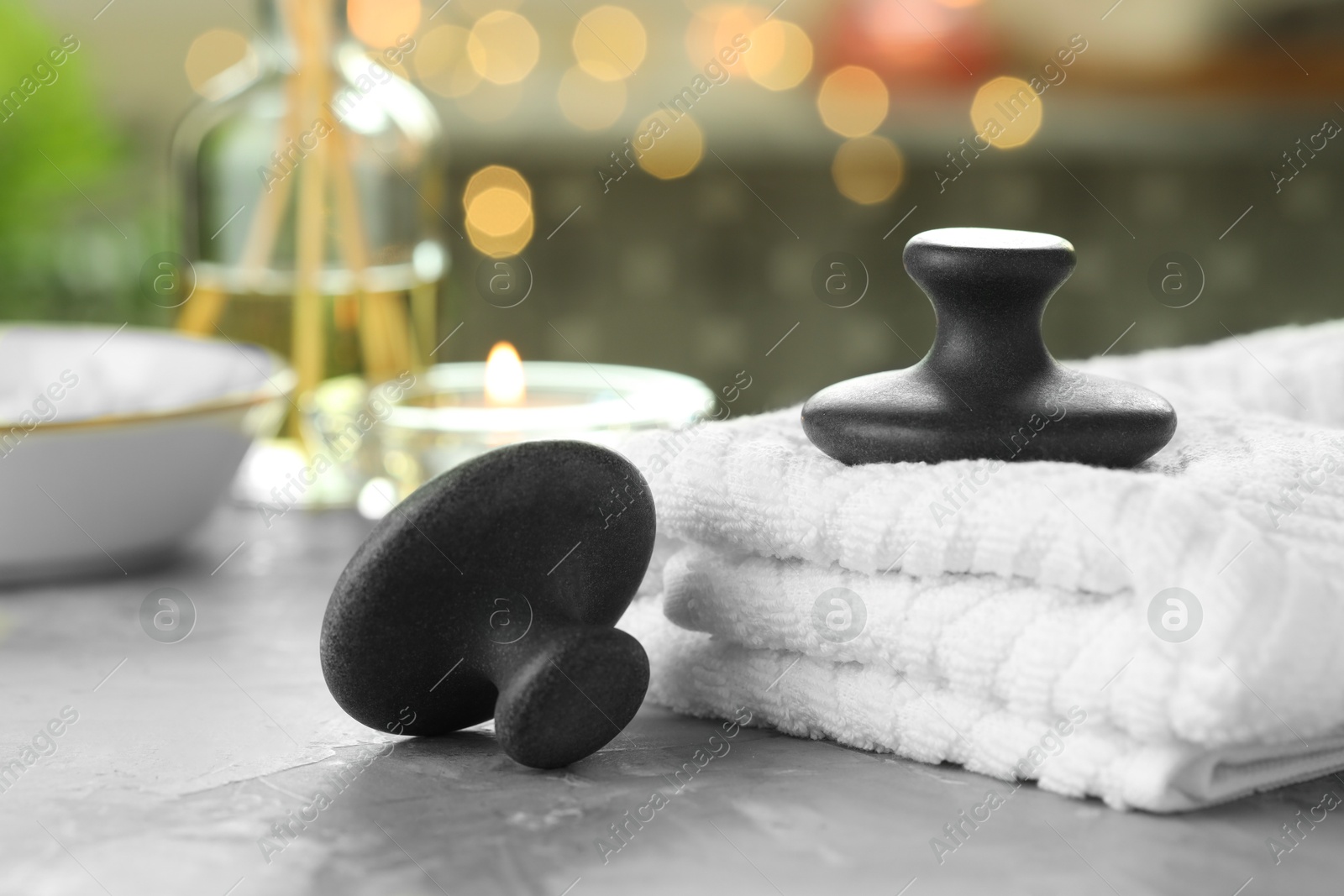 Photo of Spa stones and towels on grey background, closeup