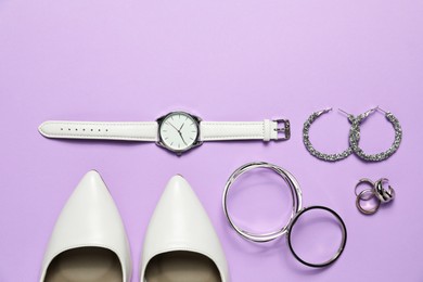 Photo of Many stylish jewelry, shoes and accessories on violet background, flat lay