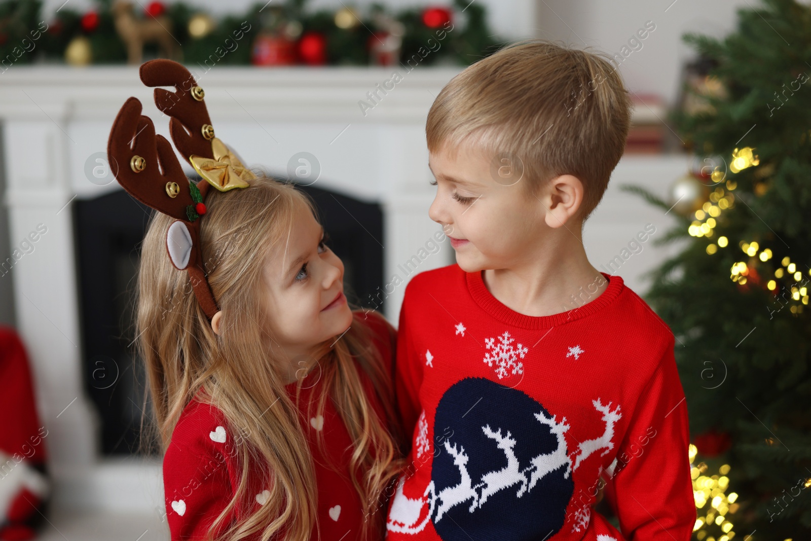 Photo of Adorable little kids in Christmas sweaters at home