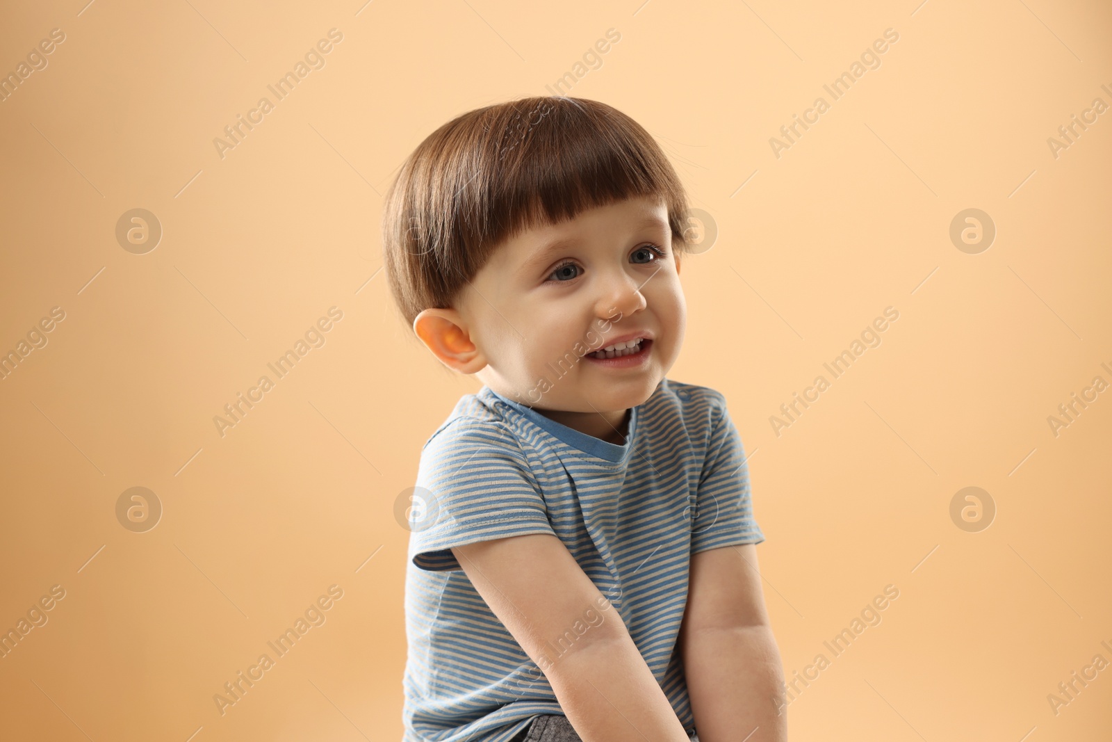 Photo of Portrait of cute little boy on beige background