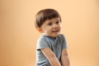 Photo of Portrait of cute little boy on beige background