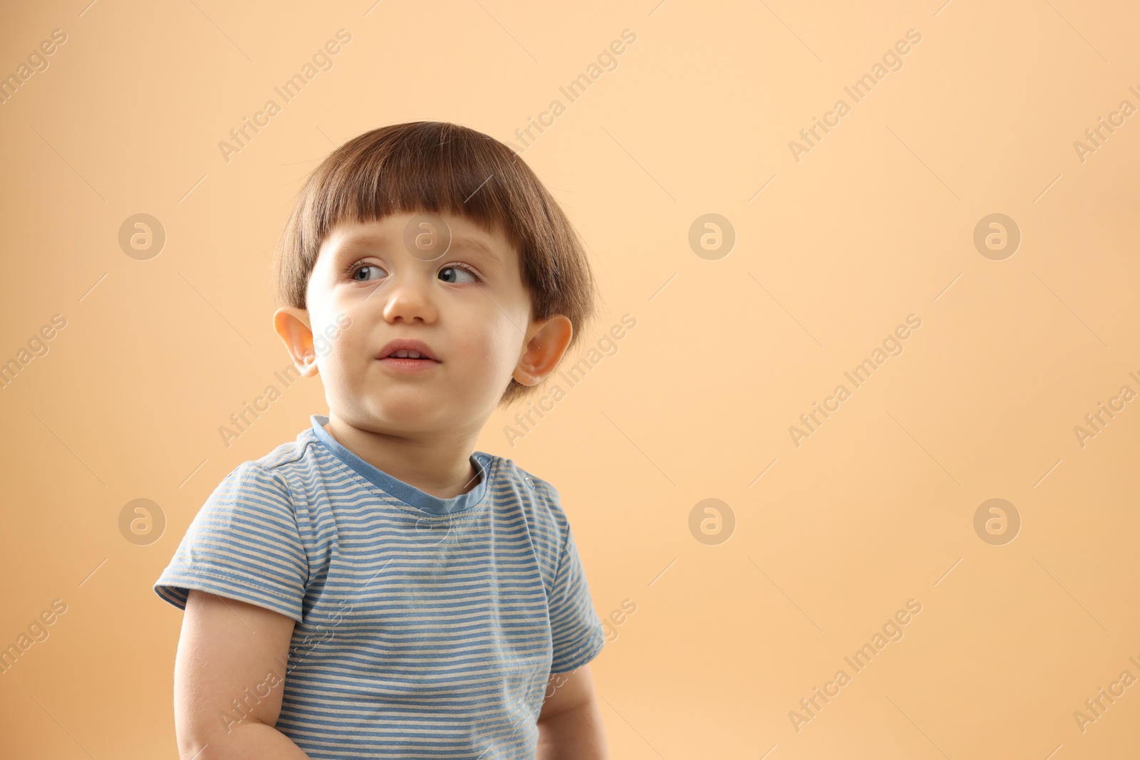 Photo of Portrait of cute little boy on beige background. Space for text