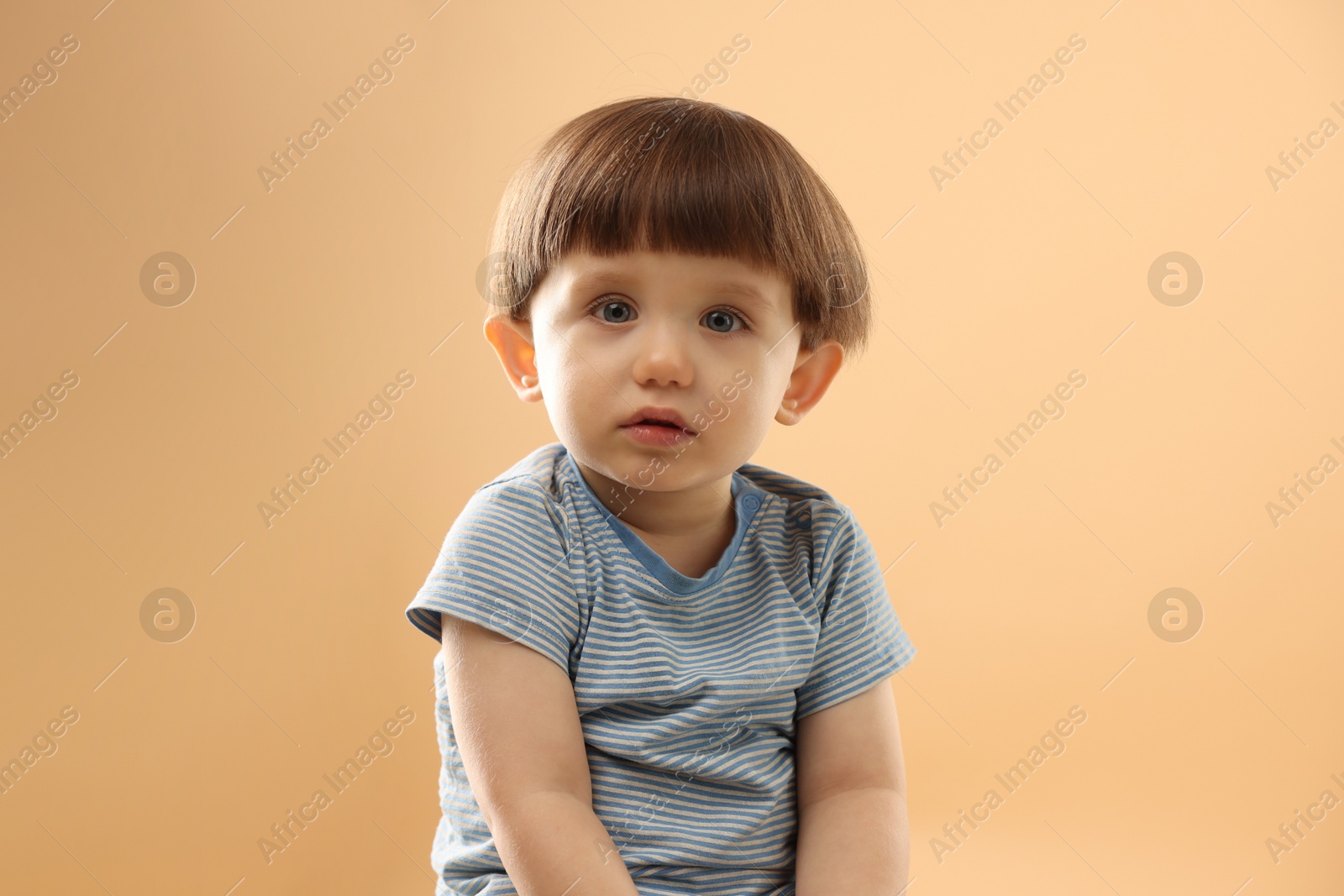 Photo of Portrait of cute little boy on beige background