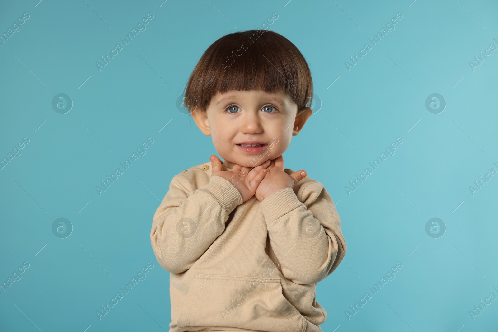 Photo of Portrait of cute little boy on light blue background