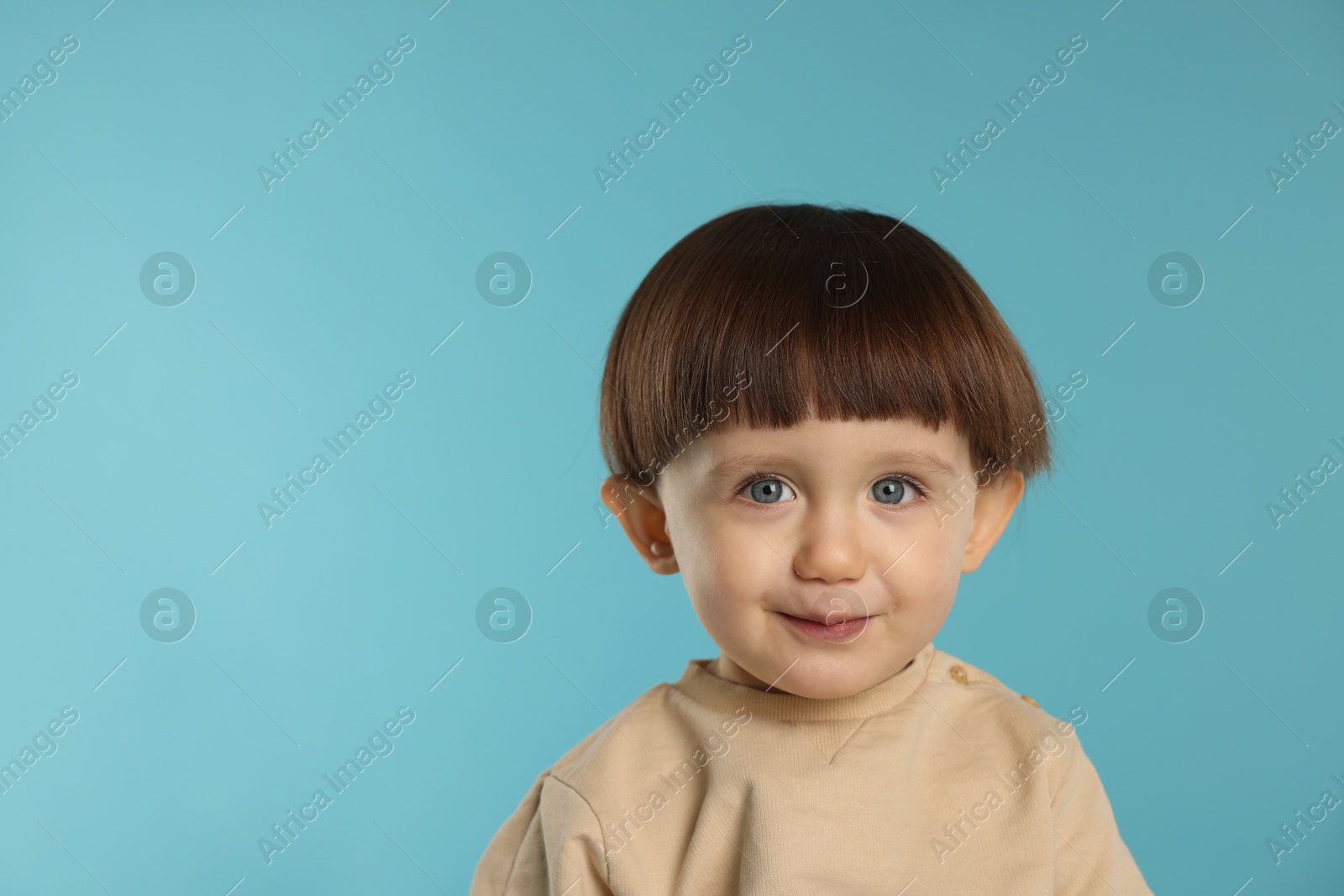 Photo of Portrait of cute little boy on light blue background. Space for text