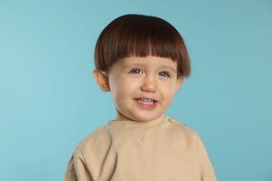 Photo of Portrait of happy little boy on light blue background