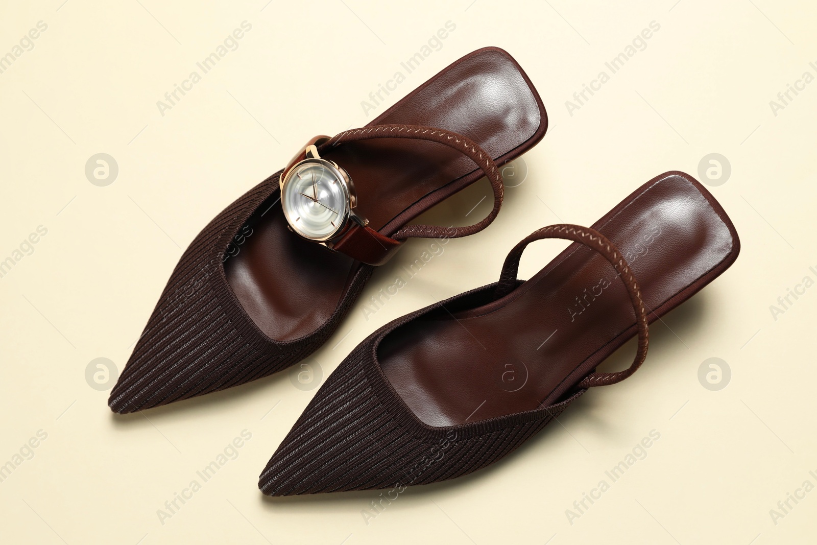 Photo of Stylish women's shoes and watch on beige background, top view