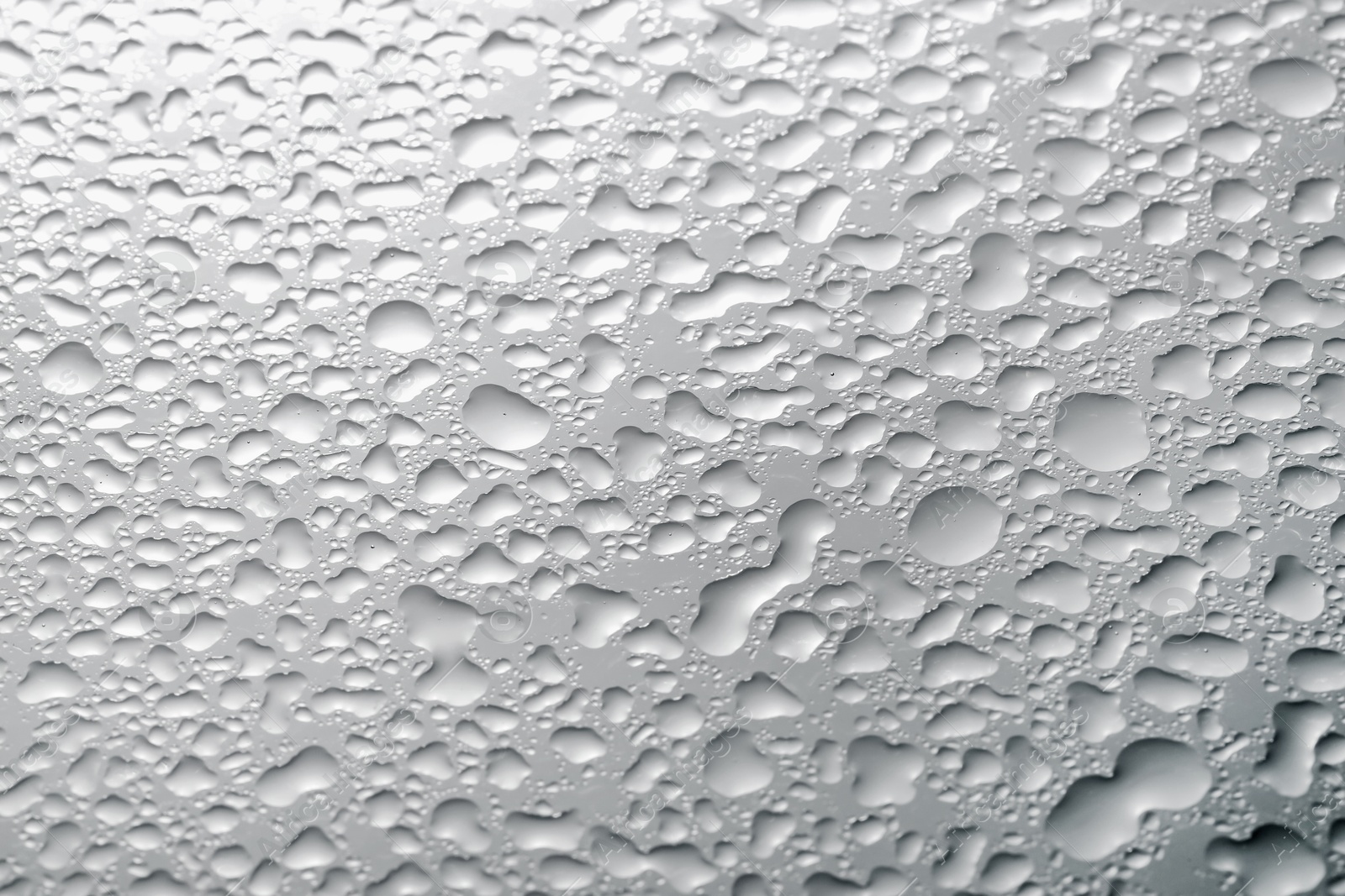 Photo of Water drops on light grey glass surface, top view