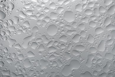 Water drops on grey glass surface, top view